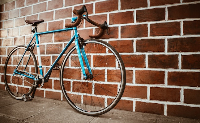 Road bike leaning on a brick wall